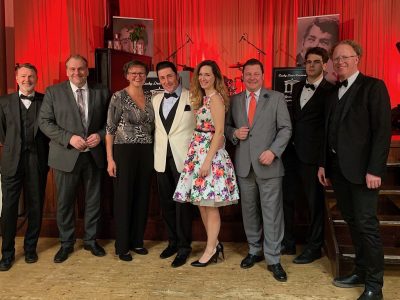 Abg. z. NR Bgm. Andreas Kollross (2. von links), des. Vbgm. Sabina Stock (3. von links), Lucky Dean Luciano (4. von links), Sängerin Annie Stettin und der des. Kulturausschussvorsitzende GGR Markus Artmann (5. von links) mit dem «The Grand Palace Tanzorchester»